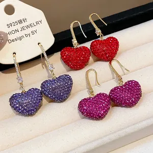 Close-up of colorful sparkling zircon heart-shaped drop earrings with S925 silver needles.