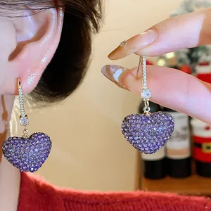 Close-up of purple heart earrings with sparkling full rhinestone and zirconia details.