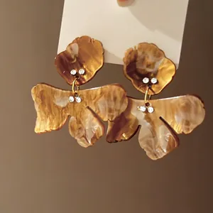 Close-up of vintage floral geometric earrings with amber marble pattern and rhinestones