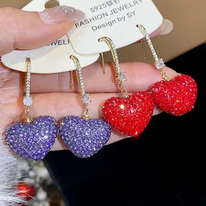 Detailed macro view of full-rhinestone heart-shaped earrings with vibrant sparkles