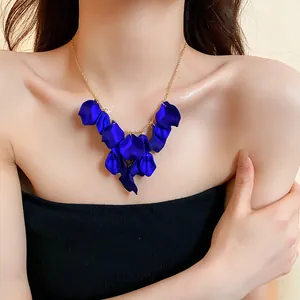 Vue détaillée d'un élégant collier de pétales bleus porté par un modèle en gros plan.