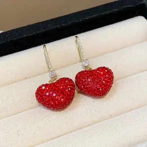Close-up view of elegant red crystal heart earrings with sparkling zircon paved hooks