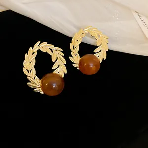 Close-up of vintage coffee-colored laurel wreath earrings with elegant amber beads