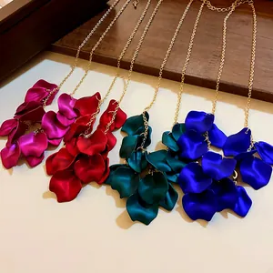 Détail de quatre colliers à glands en pétales de fleurs : magenta, rouge, sarcelle et bleu.