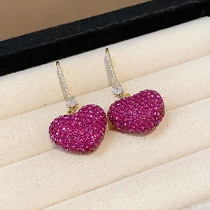 Close-up macro detail of heart earrings with sparkling pink pave zircon crystals
