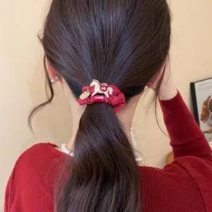 Chouchou festif en tissu rouge avec breloque cheval dorée et caractère traditionnel Fu