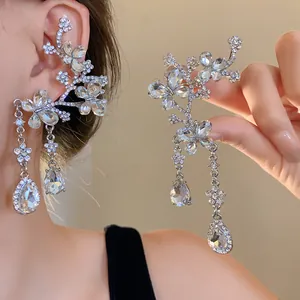 Close-up of luxury rhinestone butterfly and flower ear cuff with water drop pendants