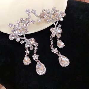 Detailed view of silver crystal butterfly drop earrings with flower motifs