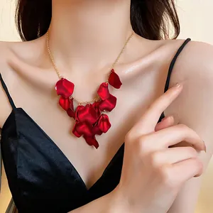 Gros plan d'un élégant collier à franges de pétales rouges avec chaîne dorée.