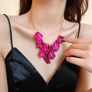Détail d'un collier à pampilles en forme de pétale magenta porté par un mannequin de mode
