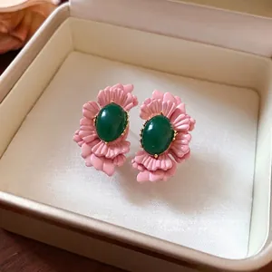 Vintage rosa Blumenstecker mit ovalem grünem Glaskern in einer Schmuckschatulle