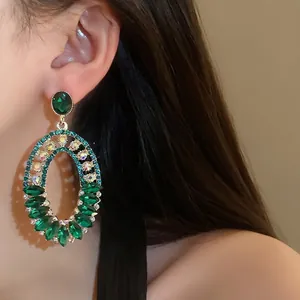 Vintage emerald green rhinestone oval statement earrings shown on an elegant model side profile