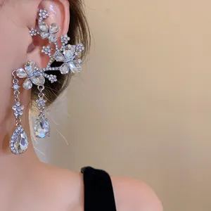 Close-up of elegant butterfly and flower ear cuff with sparkling waterdrop crystals.