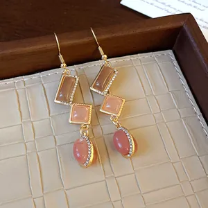 Detail of vintage geometric earrings with pink resin stones and rhinestone accents