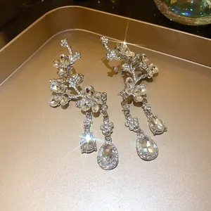 Close-up of luxury silver-tone butterfly and flower earrings with sparkling rhinestones.