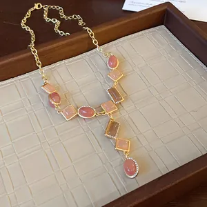 Detailed view of a vintage geometric gold necklace with elegant pink stones in a tray