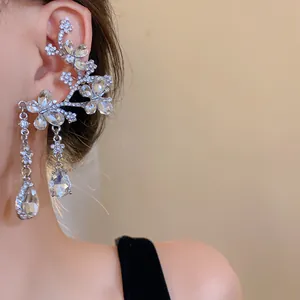 Detailed macro view of elegant silver needle earrings featuring crystal butterfly and flower motifs
