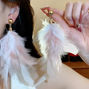 Detail of elegant silver needle earrings with long pink and white feather tassels.