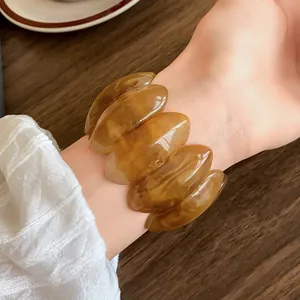 Dettagliata vista ravvicinata di un bracciale vintage in acrilico ambra a segmenti ellittici