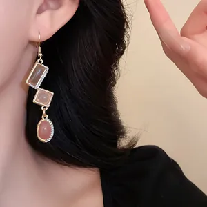Detailed view of vintage geometric dangle earrings with pink stones and rhinestones