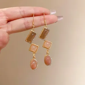 Detail shot of vintage geometric drop earrings with crystals and peach stones