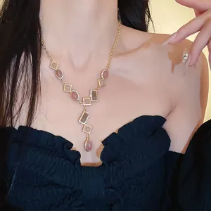 Vintage gold geometric necklace featuring pink stones on a chic black off-shoulder outfit