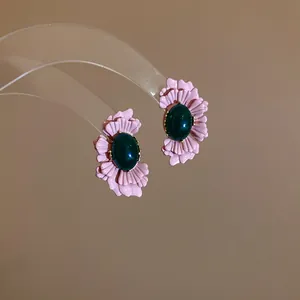 Detailansicht der rosa Blumenohrringe mit ovalen smaragdgrünen Glasedelsteinen.