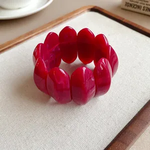 Dettaglio dei segmenti ovali in acrilico marmorizzato rosso su un bracciale chic