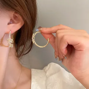 Detailed view of gold-plated hoop earrings with sparkling crystal flower accents