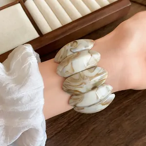 Inquadratura ravvicinata di un bracciale a maglie ovali in acrilico marmorizzato