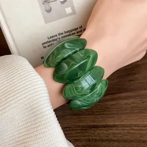 Vista dettagliata delle maglie ovali in acrilico marmorizzato verde del bracciale