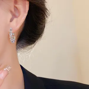 Gros plan détaillé de boucles d'oreilles créoles élégantes en argent concassé sur l'oreille
