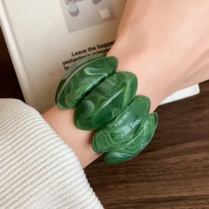 Primo piano dettagliato della trama marmorizzata di questo bracciale ovale in acrilico