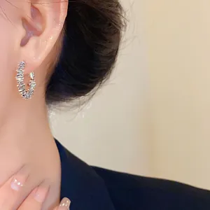 Gros plan d'élégantes créoles en argent irrégulières pour un look de bureau raffiné