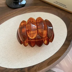 Bracelet extensible ovale en acrylique écaillé avec finition marbrée ambre.