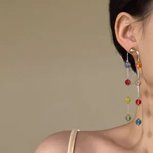 Detailed close-up view of elegant long tassel earrings with vibrant multi-colored glass beads