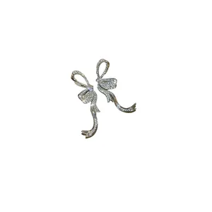 Sparkling silver needle bow tassel earrings with crystals displayed on a clean white background