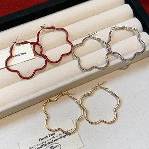 Detailed view of elegant floral-shaped hoop earrings in gold, silver, and red finishes