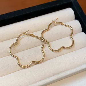 Detailed view of elegant gold flower-shaped hoop earrings resting in a velvet box