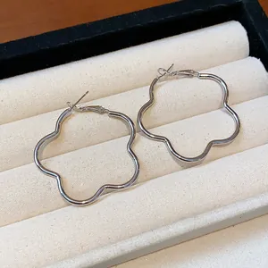 Close-up view of elegant silver-toned flower-shaped hoop earrings in jewelry box