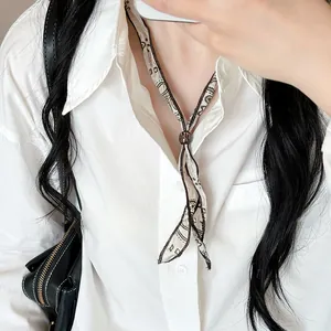 Close-up van een vintage stoffen lintketting met een donkere houten kraalschuif.