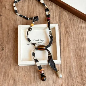 Vintage bohemian fabric beaded necklace with black and white stripes and amber acrylic bead
