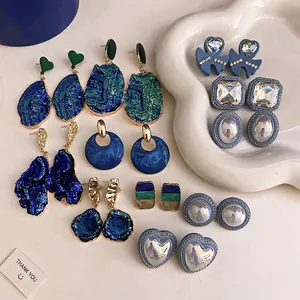 Vintage collection of blue resin and pearl heart earrings with rhinestone details.