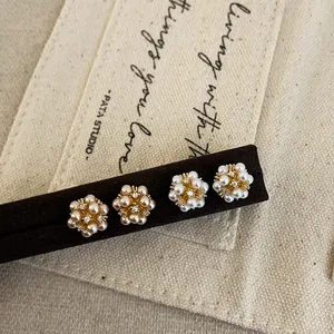 Detailed macro shot of elegant floral cluster pearl stud earrings with crystal accents