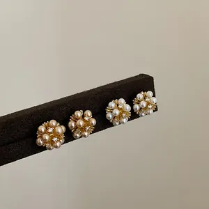 Detail showing flower cluster pearl stud earrings with shiny cubic zirconia accents