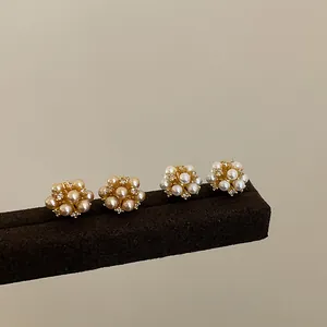 Close-up detail of elegant cluster pearl stud earrings with sparkling cubic zirconia
