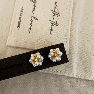 Close-up detail showing the intricate flower-shaped pearl earrings with rhinestones