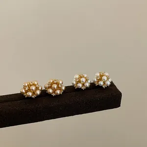 Close-up of elegant pearl flower cluster earrings in champagne and white tones