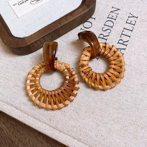 Nahaufnahme von Bohemian-Rattan-Ohrringen im Retro-Stil mit braunen Acrylsteckern