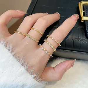 Primo piano di un set di eleganti anelli placcati oro con zirconi sulla mano